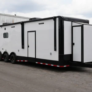 Custom cargo trailer with sleek white and black finish and polished aluminum trim, parked outdoors.